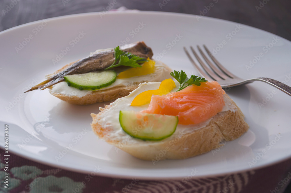 Sandwich, sandwich with salmon and sprats on a plate. Macro background. High quality photo. Banquet. Sandwich, sandwich with salmon and sprats on a plate. Macro background. High quality photo. Banquet.