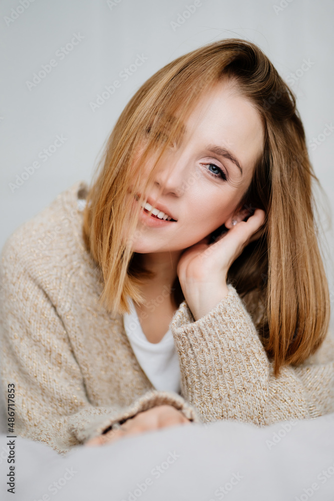 an attractive young woman in a cozy sweater. natural beauty and cosmetics.