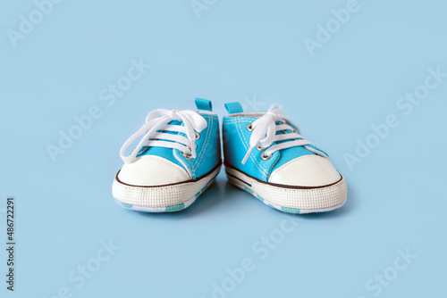 Baby's little shoes on a colorful background. The concept of waiting for a baby and the concept of traveling with baby, children's lifestyle. Copy space, flat lay