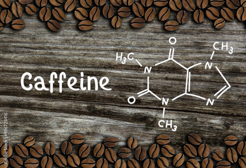 coffee beans with spoon and chemical structure of caffeine on a wooden table