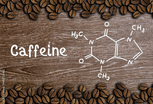 coffee beans with inscription and chemical structure of caffeine on a wooden background