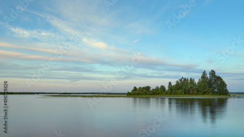 An island on the lake: summer, light calm, clouds.