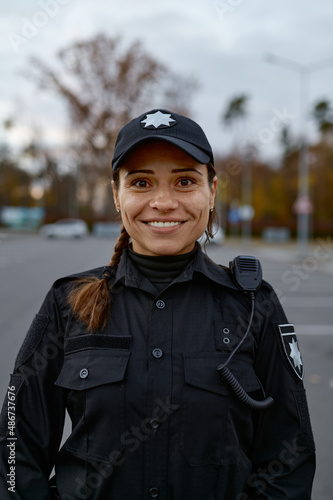 Portrait of smiling police woman on street photo