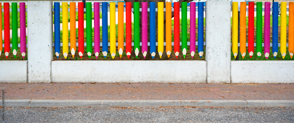 Obraz premium fence made from concrete posts and colorful wooden pickets shaped like sharped coloured pencils