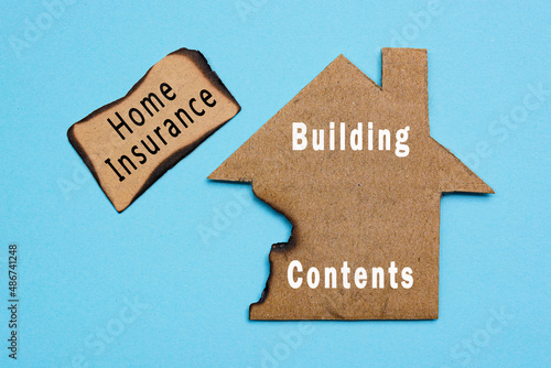 Text on burned paper house model on blue background. Home insurance concept.