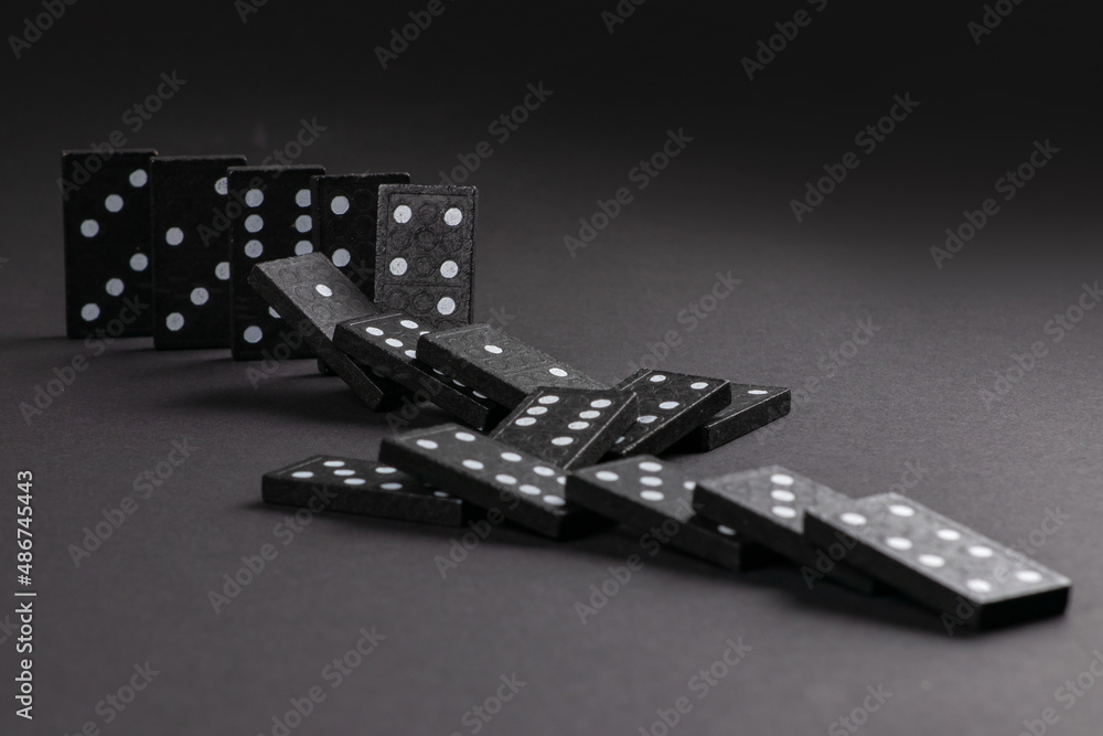 Falling dominoeson dark background. domino effect. the domino game Falling dominoeson dark background. domino effect. the domino game