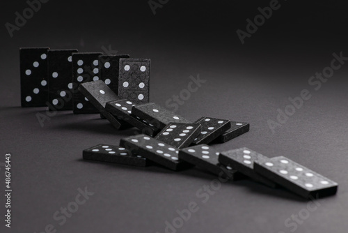 Falling dominoeson dark background. domino effect. the domino game