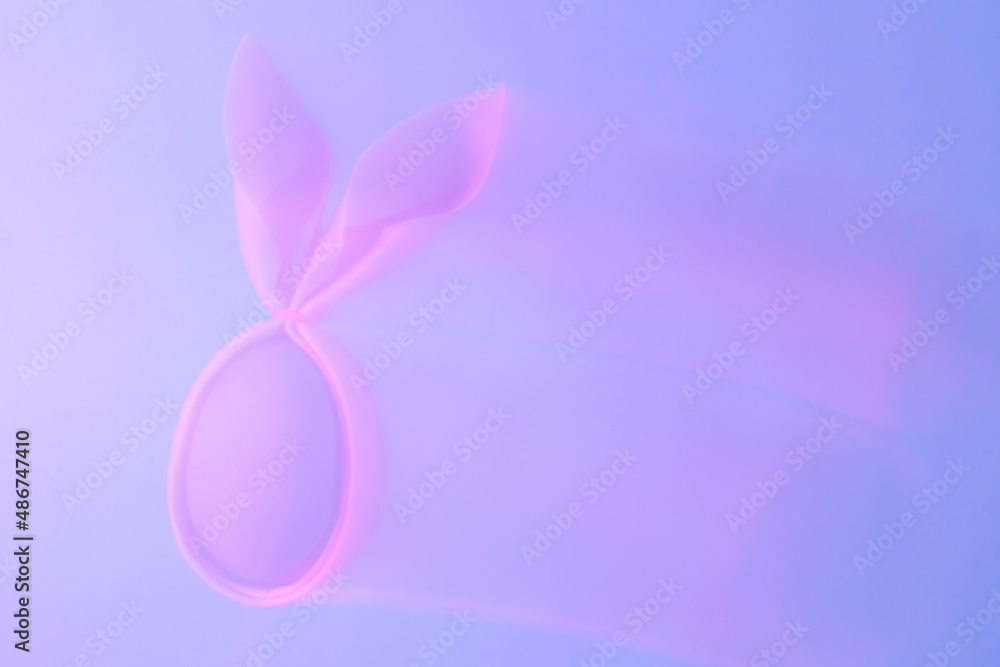 Abstract frame-washed background of neon holographic purple color trek of pink egg with rabbit ears. Creative handmade concept. Abstract frame-washed background of neon holographic purple color trek of pink egg with rabbit ears. Creative handmade concept.