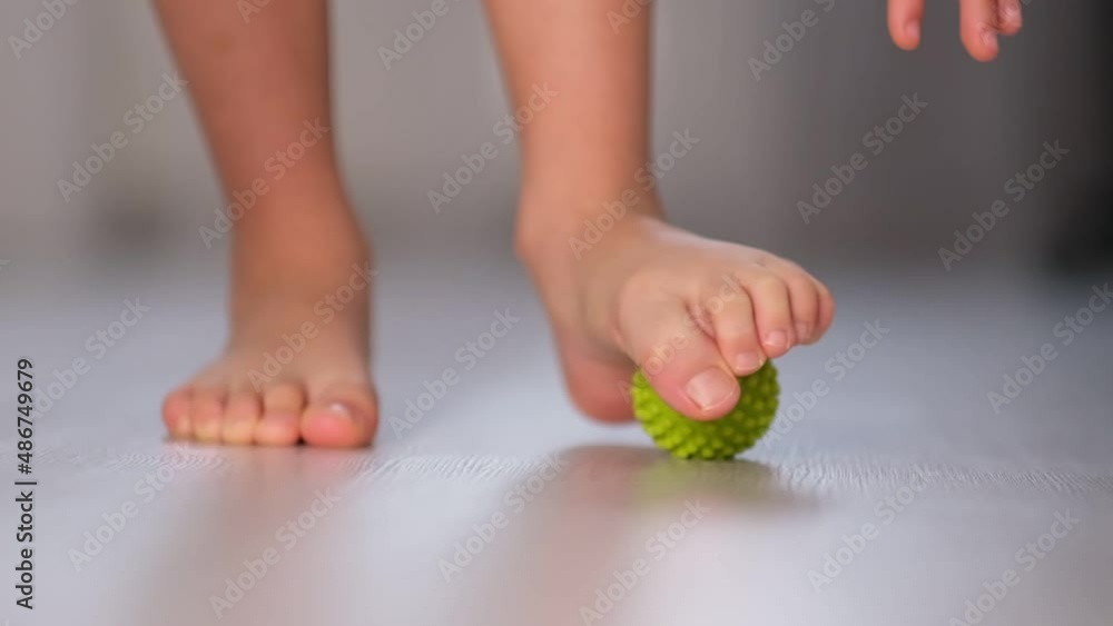Vidéo Stock Little boy massaging with ball his foot. Exercise