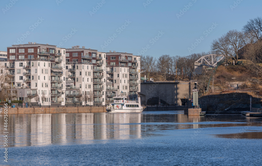Panorama view, boats and modern apartment houses at the piers in the districts around the bay Hammarby sjö in the district Södermalm a sunny winter day in Stockholm
