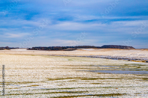 Empty winter landscape with meadows and fields on a snowy day