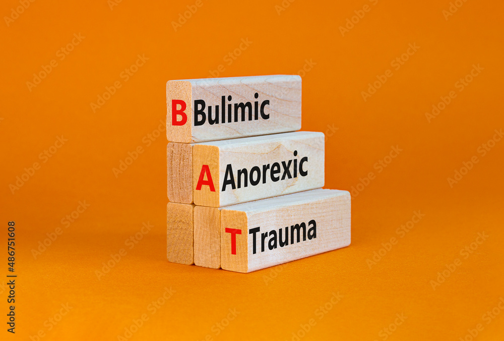 Naklejka premium BAT bulimic anorexic trauma symbol. Concept words BAT bulimic anorexic trauma on blocks on a beautiful orange table, orange background. Medical and BAT bulimic anorexic trauma concept. Copy space.