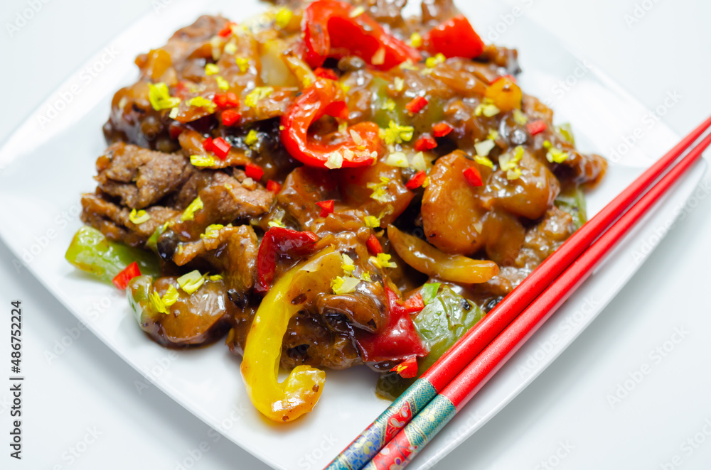 Cooked marinated beef slices with a savory black beef sauce, peppers and onions Cooked marinated beef slices with a savory black beef sauce, peppers and onions