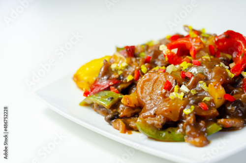 Cooked marinated beef slices with a savory black beef sauce, peppers and onions