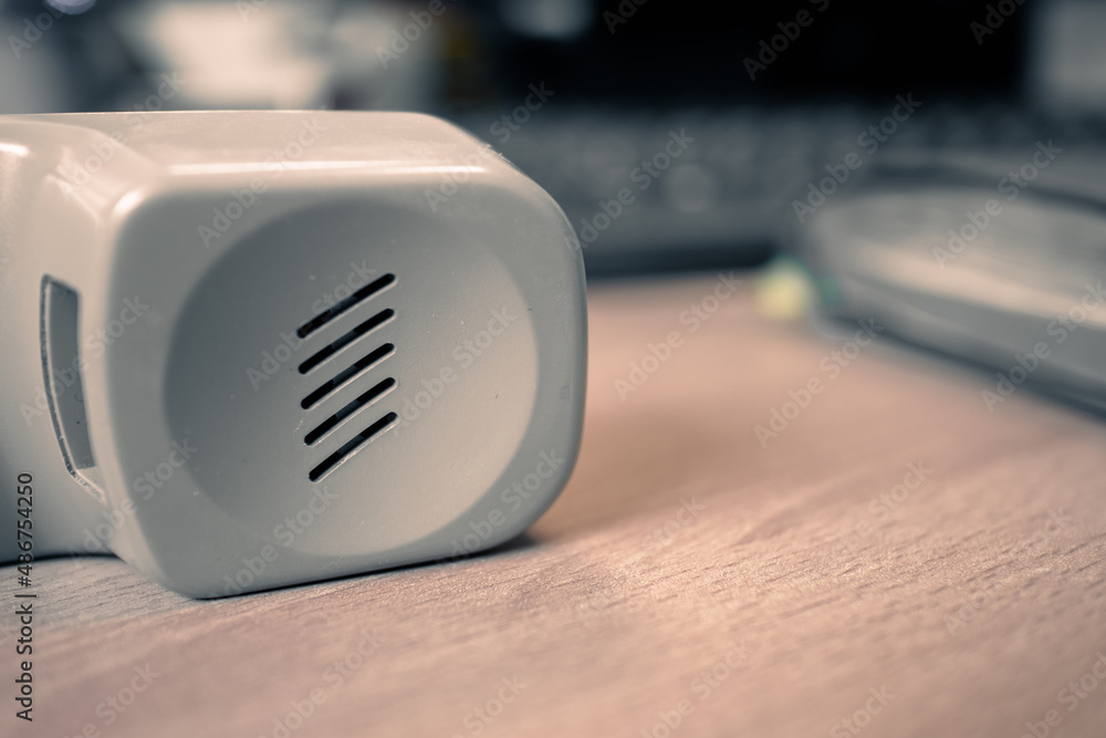 The handset of an old telephone lies on a wooden table. Retro telephone receiver lies on the desktop The handset of an old telephone lies on a wooden table. Retro telephone receiver lies on the desktop