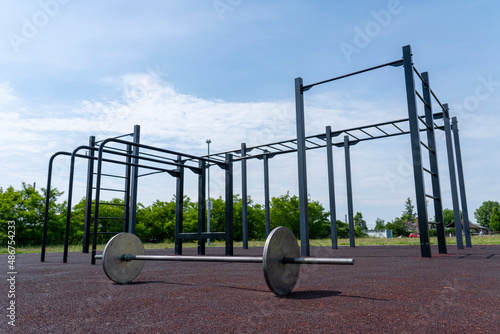 Large barbell on a training ground outdoors. Free public workout.