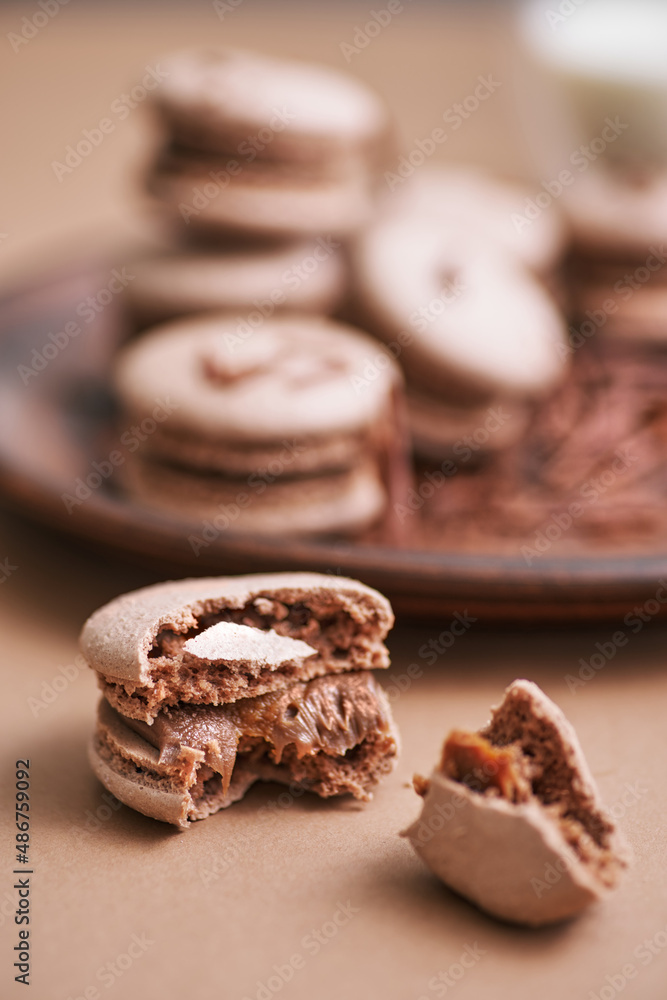 Chocolate macarons with chocolate filling. French meringue cookies macaron.