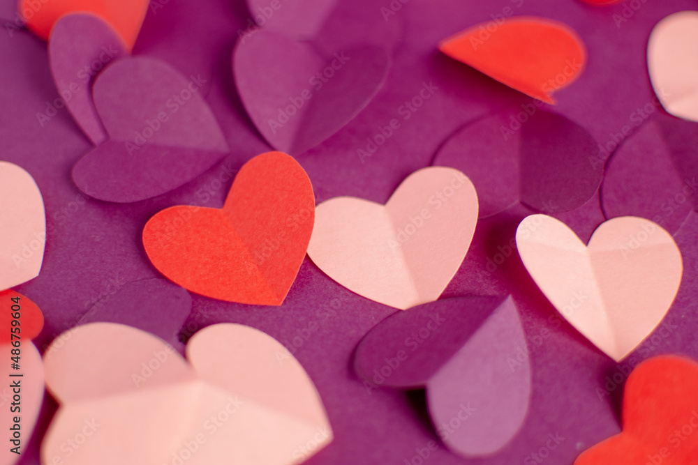 Close up pink purple red paper hearts on purple background. DIY Holiday and gift concept. Selective focus. Happy Valentine Day. Greeting card