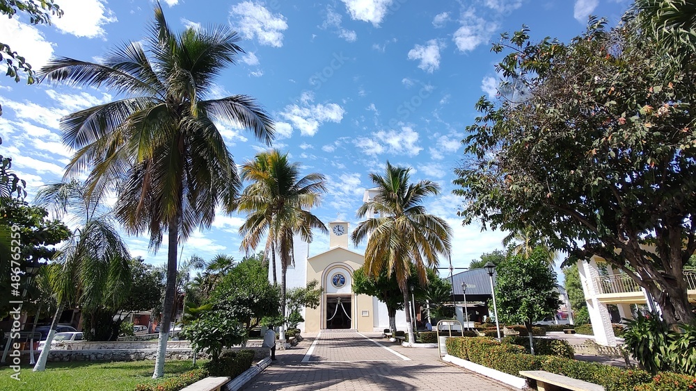Tropical park in a town with a church 