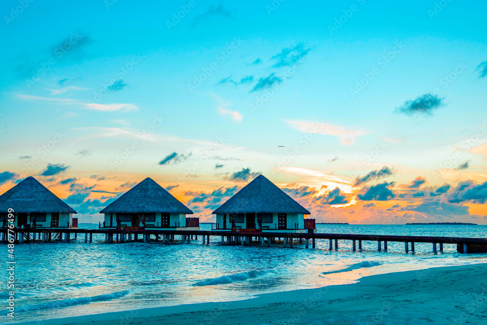 view of the water villas at sunrise in the Maldives, the concept of luxury travel