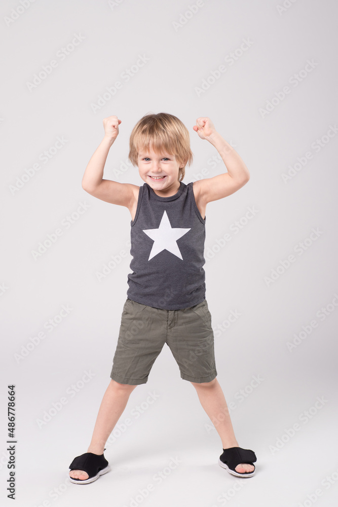Little boy, caucasian having fun, doing exercises, gesturing on a studio background. Full height. The concept of childhood, development, child. Little boy, caucasian having fun, doing exercises, gesturing on a studio background. Full height. The concept of childhood, development, child.