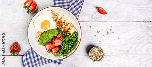 Delicious breakfast or snack Buddha bowl with Chicken salad with arugula and strawberries. Healthy food, ketogenic diet, diet lunch concept. Keto Paleo diet menu. Top view