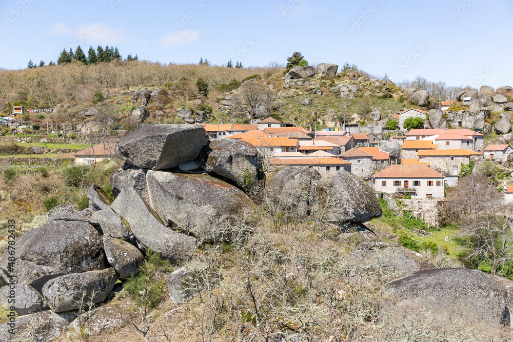 a view of Castelo village (Telões) with big boulders in the foreground, Vila Pouca De Aguiar, district of Vila Real, Portugal - April 2019
