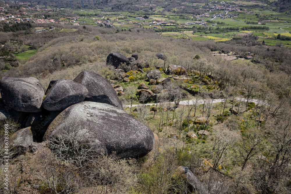 a view over the green valley of Vila Pouca de Aguiar with big boulders in the foreground, district of Vila Real, Portugal