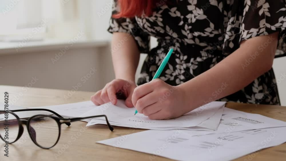 Young girl student is writing test paper in lesson at university or college.