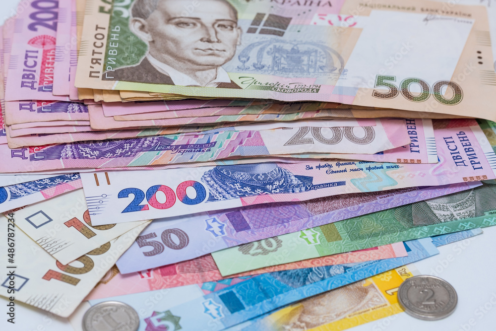 Obraz premium Ukrainian hryvnia and coins, background. Concept of receiving a salary, pension, inflation, deposit and credit. Concept of increasing the price of utilities, energy, gast
