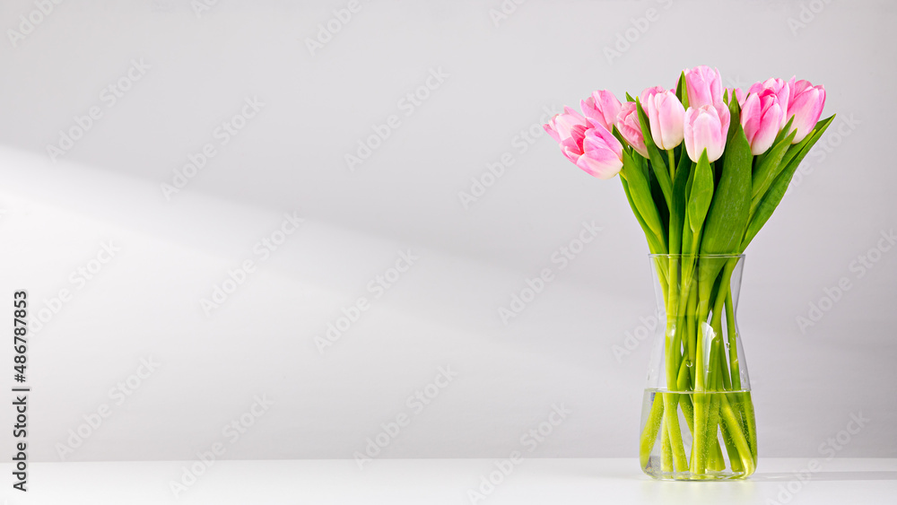 Εκτύπωση καμβά Pink tulips in a vase on a white table