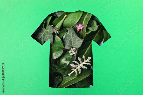 Paper cut t-shirt shape filled with green leaves. Organic cotton production, sustainable, ethical shopping, slow, circular fashion concept photo