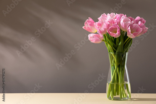 Pink tulips in a vase on a table photo