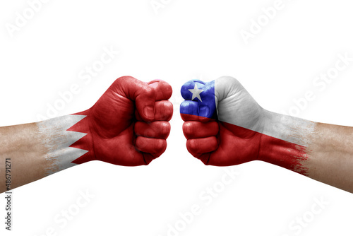 Two hands punch to each others on white background. Country flags painted fists, conflict crisis concept between bahrain and chile