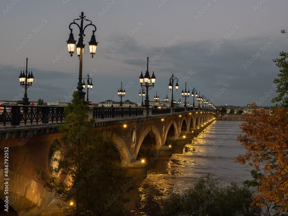 Sunset at Pont de pierre by the light of street lamps in Bordeaux, France.