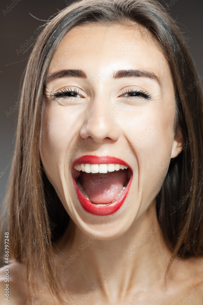 Beautiful brunette girl studio portrait. Screaming and surprised expression. Beautiful brunette girl studio portrait. Screaming and surprised expression.