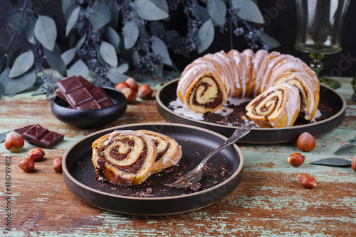 Traditional Polish babka bundt cake with hazelnuts  chocolate and icing sugar glaze served as close-up on a Nordic design plate