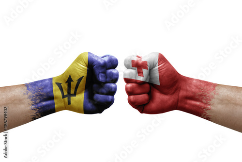 Two hands punch to each others on white background. Country flags painted fists, conflict crisis concept between barbados and tonga