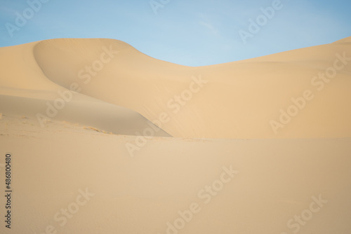 Sandy dune against a blue sky