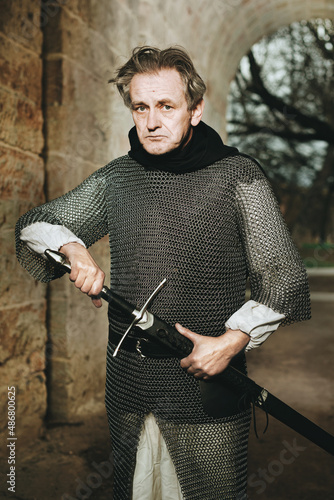 Medieval infantry armed man on guard in castle gateway photo