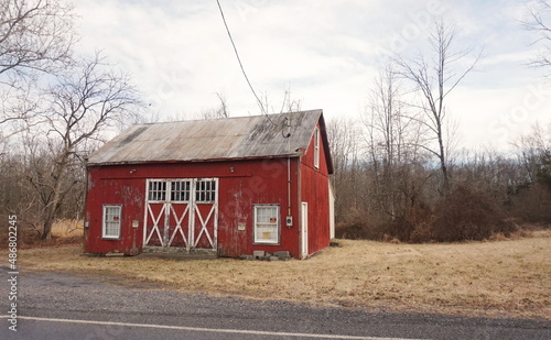 Weathered Red Wood Side Barn with Tin Roof in Winter Daylight photo