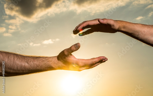 Two man hands. Sky background. Man. Male. Hand