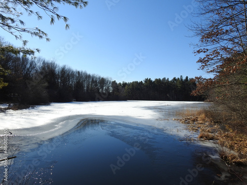 The beautiful winter scenery of a partially frozen Lake Wintergreen, in West Rock Ridge State Park, Hamden, Connecticut.