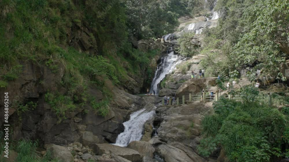 Unrecognizable tourists enjoying beautiful Ravana Falls, Sri Lanka. Static Unrecognizable tourists enjoying beautiful Ravana Falls, Sri Lanka. Static
