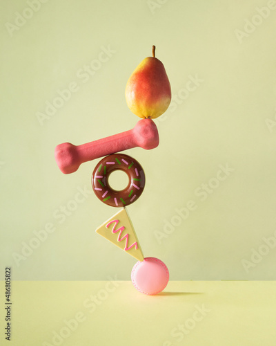 Creative balanced lifestyle concept. Minimalistic composition with sweets, fruit and workout on pastel yellow background. Eating healthy food idea. photo