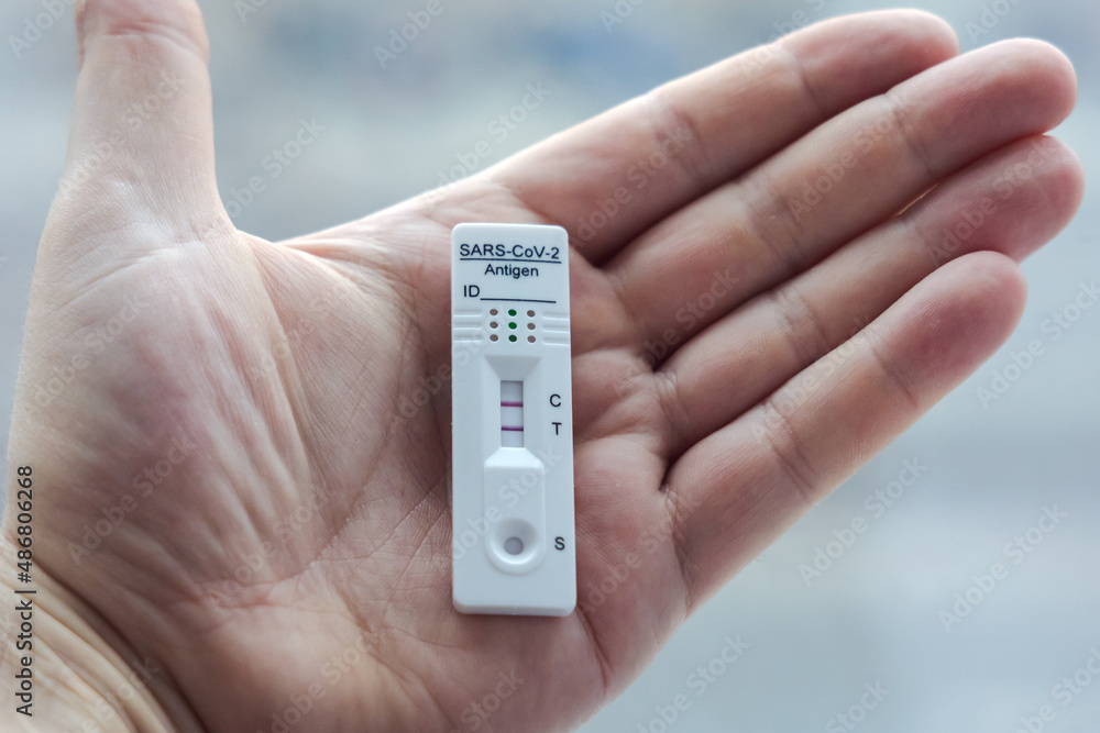 Man holds a SARS-CoV-2 rapid antigen test with positive result of coronavirus infection Man holds a SARS-CoV-2 rapid antigen test with positive result of coronavirus infection