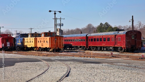 Vintage Pullman rail cars and caboose sitting on a track at a museum.  