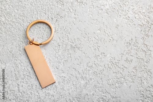 Photos Stylish bronze keychain on light background