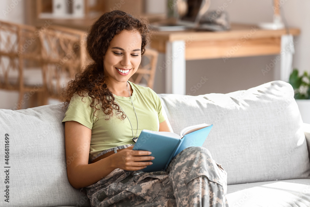 African-American female soldier reading book at home African-American female soldier reading book at home