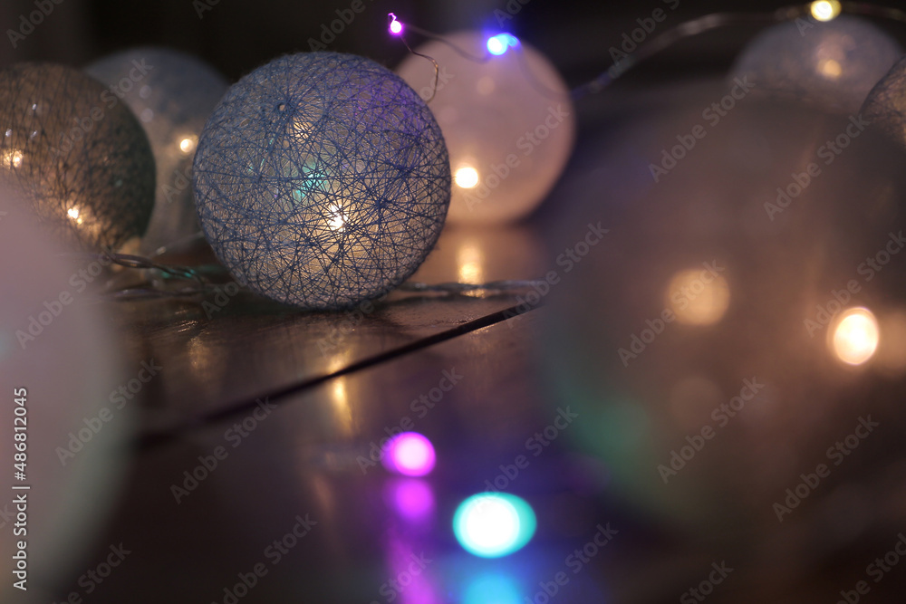 Fototapeta premium Bright glitter luminous garland in the dark, wicker balls wonderful home decor. Place for your text